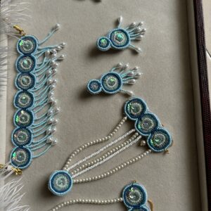 Elegant handmade jewelry featuring intricate threadwork and dazzling sequins, complemented by pearl beads. A perfect blend of traditional craftsmanship and modern elegance.